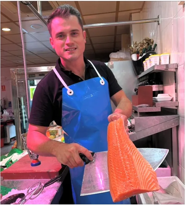 Alfredito mostrando un lomo de salmón en el mostrador