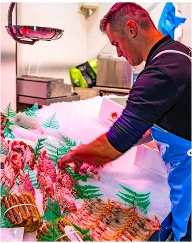 Alfredito preparando el mostrador de género fresco